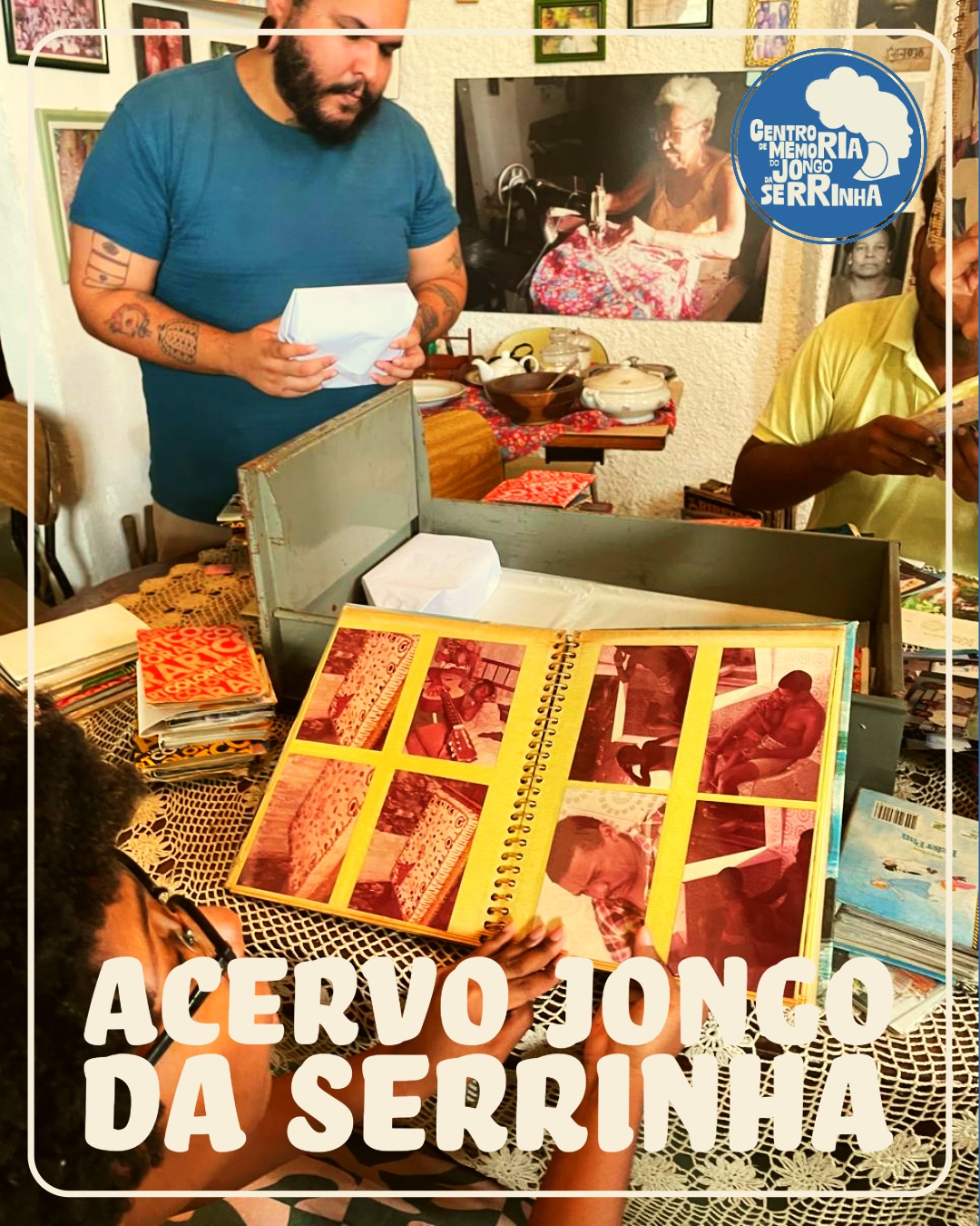 Três pessoas examinam fotografias e documentos antigos em uma mesa, com um grande álbum de fotos aberto em primeiro plano. A legenda da imagem diz: “ACERVO JONGO DA SERRINHA — Centro de Memória Jongo da Serrinha”.